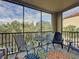 Relaxing screened balcony with patio furniture and view of lush greenery at 1361 Tuscan Ter # 7305, Davenport, FL 33896