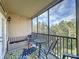 Enjoy this screened balcony featuring a table, chairs, and storage bench at 1361 Tuscan Ter # 7305, Davenport, FL 33896