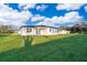 Backyard view of home featuring lush green lawn and exterior in white and black trim at 15771 Sw 19Th Avenue Rd, Ocala, FL 34473