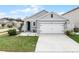 Gray house with white garage door and landscaping at 1956 Egret Meadows Ave, Kissimmee, FL 34744