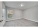 Simple bedroom with grey carpet, white trim, and a window at 22 Peterlee Ct, Kissimmee, FL 34758