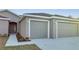 Two-car garage with a walkway to the home's entrance at 22 Peterlee Ct, Kissimmee, FL 34758