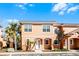 Two story townhome with light orange exterior and landscaping at 2621 Bugatti Ct, Kissimmee, FL 34746