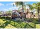 Back exterior view showing a house with a screened patio and lush landscaping at 2621 Bugatti Ct, Kissimmee, FL 34746