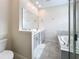 Bright bathroom with a double vanity, large mirror, soaking tub, and tiled floor at 272 Muscogee Ln, Orlando, FL 32825