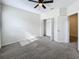 Large bedroom with neutral carpeting, a ceiling fan, and double doors to the closet at 272 Muscogee Ln, Orlando, FL 32825