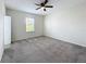 Spacious bedroom featuring neutral carpeting, a ceiling fan, and a sunlit window at 272 Muscogee Ln, Orlando, FL 32825