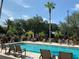 Resort-style pool with lounge chairs and palm trees at 3000 Maingate Ln # 228, Kissimmee, FL 34747