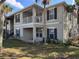 Two-story condo building with light beige exterior, dark gray shutters, and a private balcony at 3011 Hemingway Cir # 3011, Haines City, FL 33844