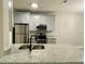 Modern kitchen with gray cabinets, granite countertops, stainless steel appliances, and a breakfast bar at 3011 Hemingway Cir # 3011, Haines City, FL 33844