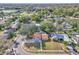 Wide aerial view showcasing the home's location in a neighborhood with mature trees and nearby lake at 3020 Rockingham Cir, Orlando, FL 32808