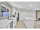Modern kitchen with white cabinets, stainless steel appliances, and an island, connecting to living area fireplace at 3020 Rockingham Cir, Orlando, FL 32808