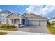 Two-story house with gray siding, three-car garage, and landscaped front yard at 3052 Ella Way, Saint Cloud, FL 34771