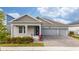 Two-story house with gray siding, three-car garage, and landscaped front yard at 3052 Ella Way, Saint Cloud, FL 34771