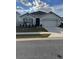 One-story home with two-car garage, landscaping, and a neutral color palette at 3309 Sonder Dr, Davenport, FL 33896