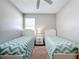 Twin bedroom with light teal bedding and a shared bathroom at 370 Henley Cir, Davenport, FL 33896