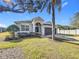 Single-story house with gray exterior, dark garage door, and palm tree at 370 Henley Cir, Davenport, FL 33896