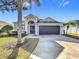 House exterior with gray walls, dark brown garage door, and landscaping at 370 Henley Cir, Davenport, FL 33896
