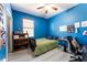 Blue bedroom with a bed, desk and window with blinds at 435 Madina Cir, Davenport, FL 33837