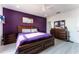Main bedroom with a deep purple accent wall and wood furniture at 435 Madina Cir, Davenport, FL 33837