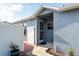 Charming entrance featuring gray siding, screen door, a white gate, and a walkway with potted plants at 435 Madina Cir, Davenport, FL 33837