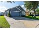 Blue single-Gathering home with a two-car garage and well-manicured lawn on a sunny day at 435 Madina Cir, Davenport, FL 33837