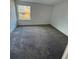 Spacious bedroom with gray carpet and window at 4518 Commander Dr # 1918, Orlando, FL 32822