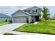 Two-story house with gray siding, two-car garage, and landscaped lawn at 4571 Calumet Dr, Saint Cloud, FL 34772