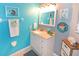 Bright bathroom with teal walls, white vanity, and decorative accents at 4724 Vero Beach Pl, Kissimmee, FL 34746