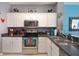 White kitchen cabinets, stainless steel appliances, and dark countertops at 4724 Vero Beach Pl, Kissimmee, FL 34746