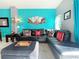 L-shaped black leather sectional sofa with Disney decor in a teal living room at 4724 Vero Beach Pl, Kissimmee, FL 34746