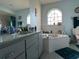 Bathroom with a large corner tub and gray vanity at 648 Tradewinds Dr, Deltona, FL 32738