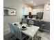 Bright dining area adjoining modern kitchen featuring white cabinets, stainless steel appliances and an elegant dining table at 701 Ocean Course Ave, Davenport, FL 33896