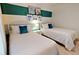 Bedroom with two twin beds, beach-themed wall art, and teal accent wall at 8906 Shine Dr, Kissimmee, FL 34747
