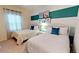 Bedroom with two twin beds, beach-themed wall art, and teal accent wall at 8906 Shine Dr, Kissimmee, FL 34747