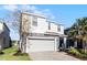 Two-story house with gray siding, stone accents, and a gray garage door at 8953 Zurich Ln, Kissimmee, FL 34747