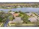 Aerial view of homes near a lake featuring mature trees, screened patios, and well-maintained lawns at 900 Shorehaven Drive, Poinciana, FL 34759