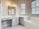 Bathroom featuring a soaking tub, vanity with seating area, and window with natural light at 900 Shorehaven Drive, Poinciana, FL 34759