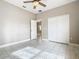 Bright bedroom featuring white tile flooring, ceiling fan, and an open doorway to another room at 900 Shorehaven Drive, Poinciana, FL 34759