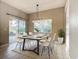 Dining area with a modern chandelier, white chairs, and a sliding glass door leading to the patio at 900 Shorehaven Drive, Poinciana, FL 34759