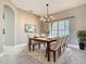 Dining room with elegant chandelier, modern artwork, and a large window at 900 Shorehaven Drive, Poinciana, FL 34759