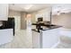 Bright kitchen features white cabinets, black countertops, and a breakfast bar for casual dining at 900 Shorehaven Drive, Poinciana, FL 34759