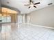 Bright living area showcasing tile floors, ceiling fan, and easy access to other rooms and entry at 900 Shorehaven Drive, Poinciana, FL 34759