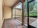Screened patio with brick floor offers a relaxing outdoor space with views of the landscaped yard at 900 Shorehaven Drive, Poinciana, FL 34759