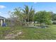 Lush backyard with a screen-enclosed lanai, tropical plants, and open green space at 918 San Paulo Way, Kissimmee, FL 34758