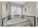 Bright bathroom featuring a soaking tub, tile surround, and natural light from the window at 918 San Paulo Way, Kissimmee, FL 34758