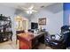 Home office with a decorative blue accent wall, built-in shelving, and ceiling fan at 918 San Paulo Way, Kissimmee, FL 34758