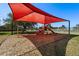 Neighborhood playground with a red shade cover and a variety of play equipment at 918 San Paulo Way, Kissimmee, FL 34758