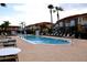 Community pool with tables and chairs and lounge chairs at 1068 Lake Berkley Dr, Kissimmee, FL 34746