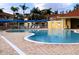 Kidney shaped community pool with plenty of lounge chairs at 1068 Lake Berkley Dr, Kissimmee, FL 34746